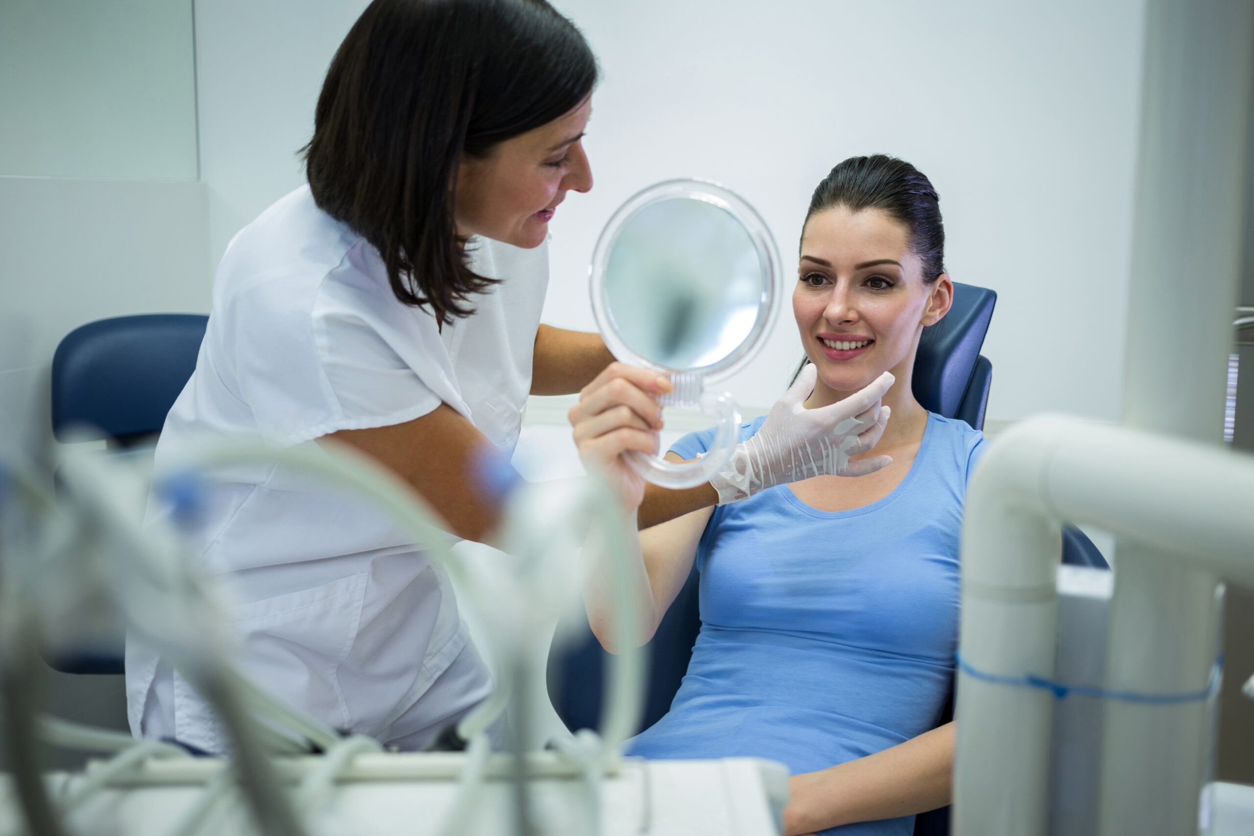 Doctor examining female patients face at clinic